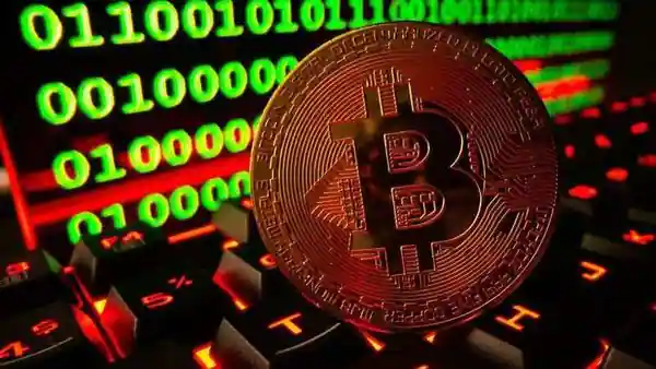 Bitcoin cryptocurrency representation is pictured on a keyboard in front of binary code in this illustration. (REUTERS)